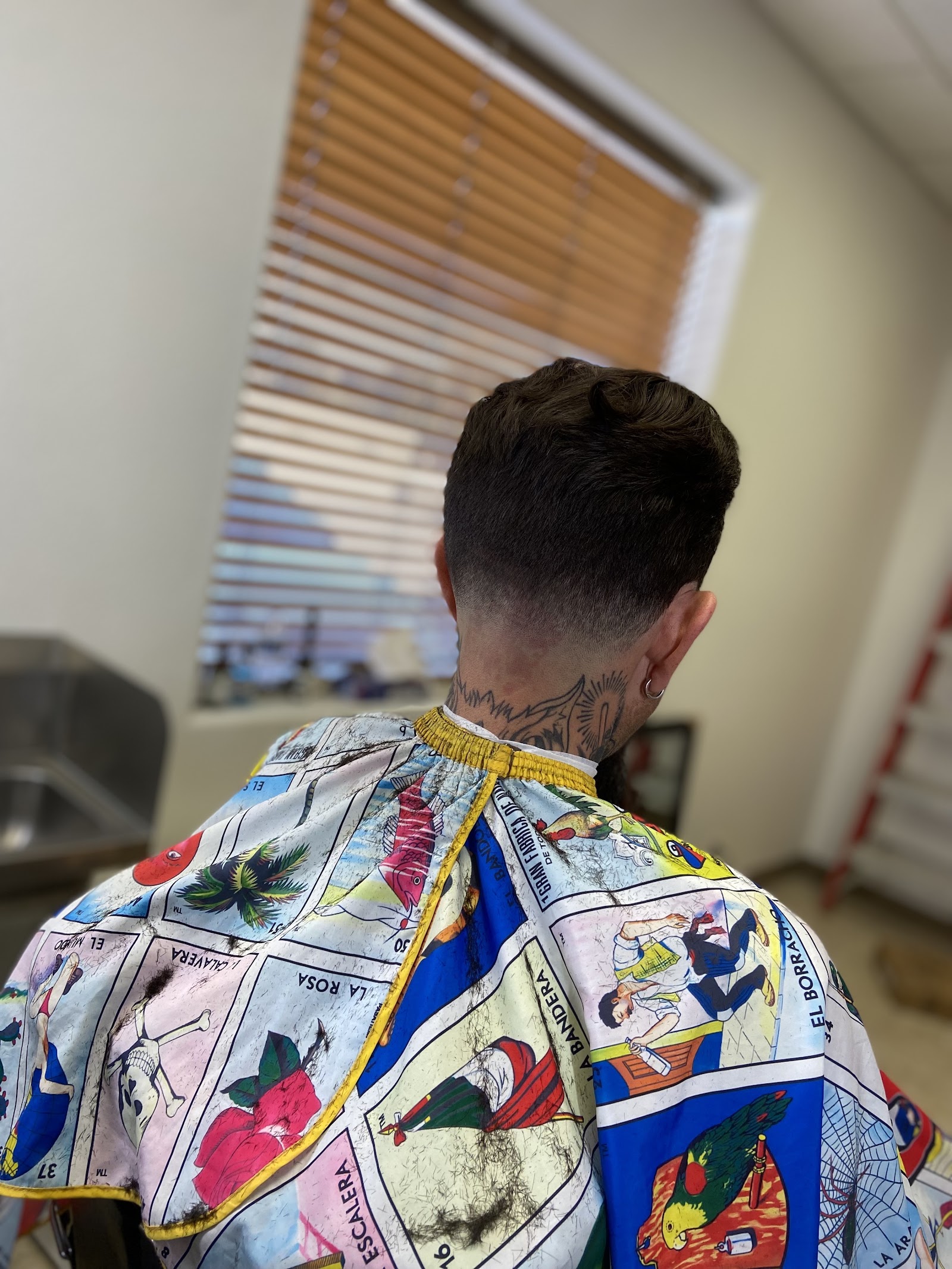 Back view of a men's mullet-style haircut with a low fade
